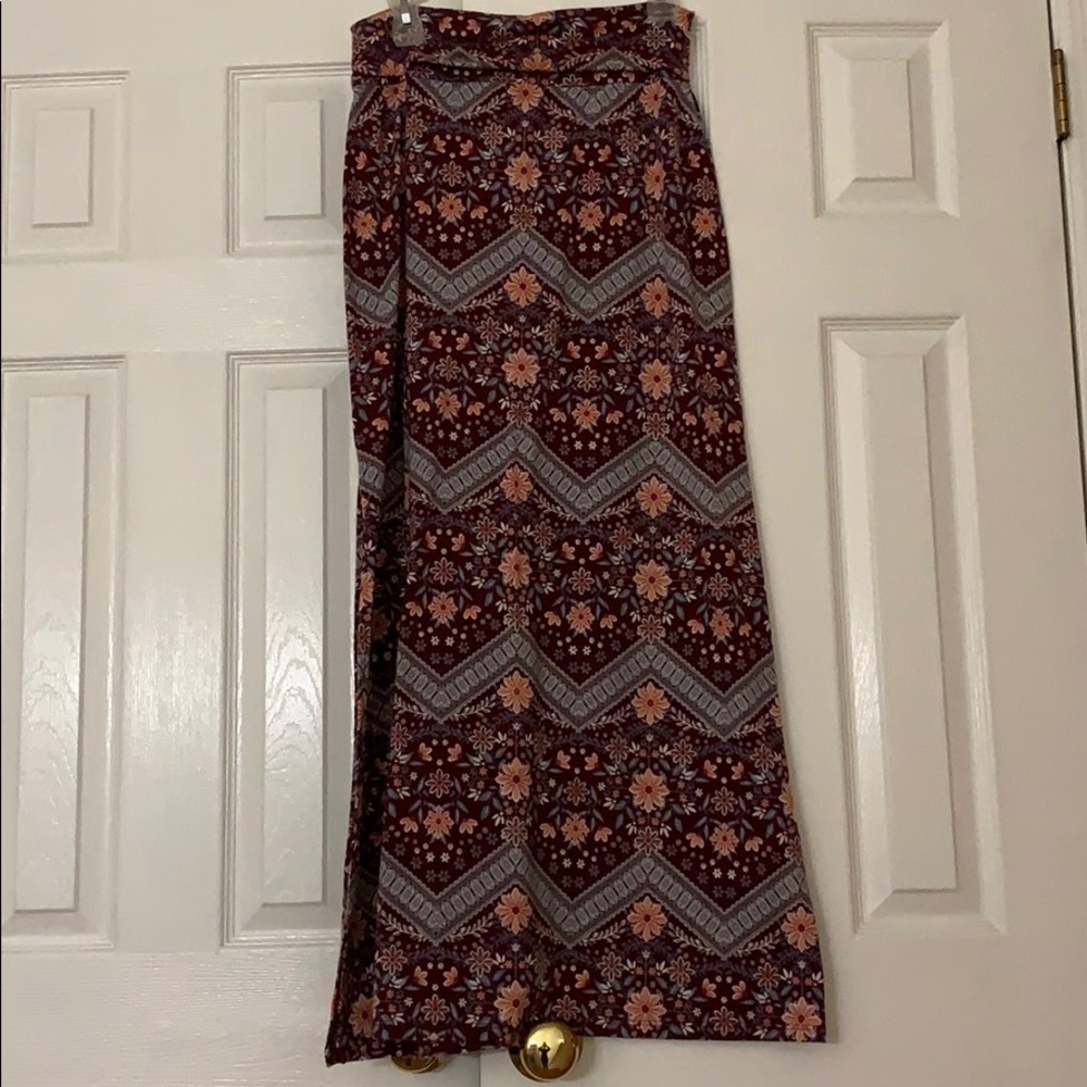 Long skirt, background is maroon color.